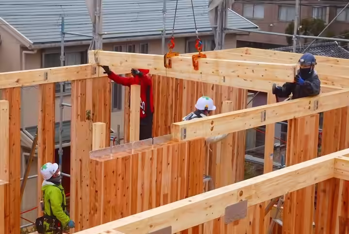 クレーンで木材を吊り上げるCLT木造建築の施工現場