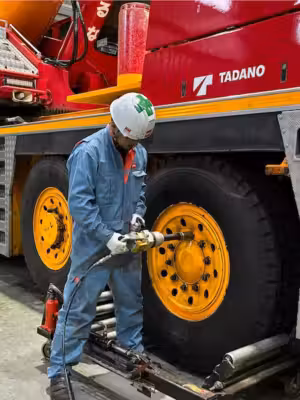クレーン車両のタイヤ周辺を点検する車両エンジニア